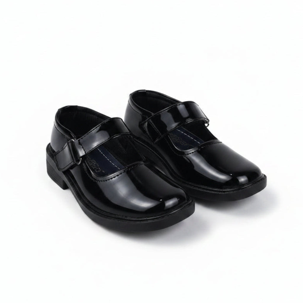 A pair of black patent leather Mary Jane school shoes with hook-and-loop straps, shown on a plain white background.