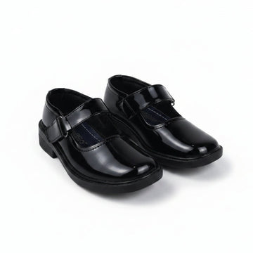 A pair of black patent leather Mary Jane school shoes with hook-and-loop straps, shown on a plain white background.
