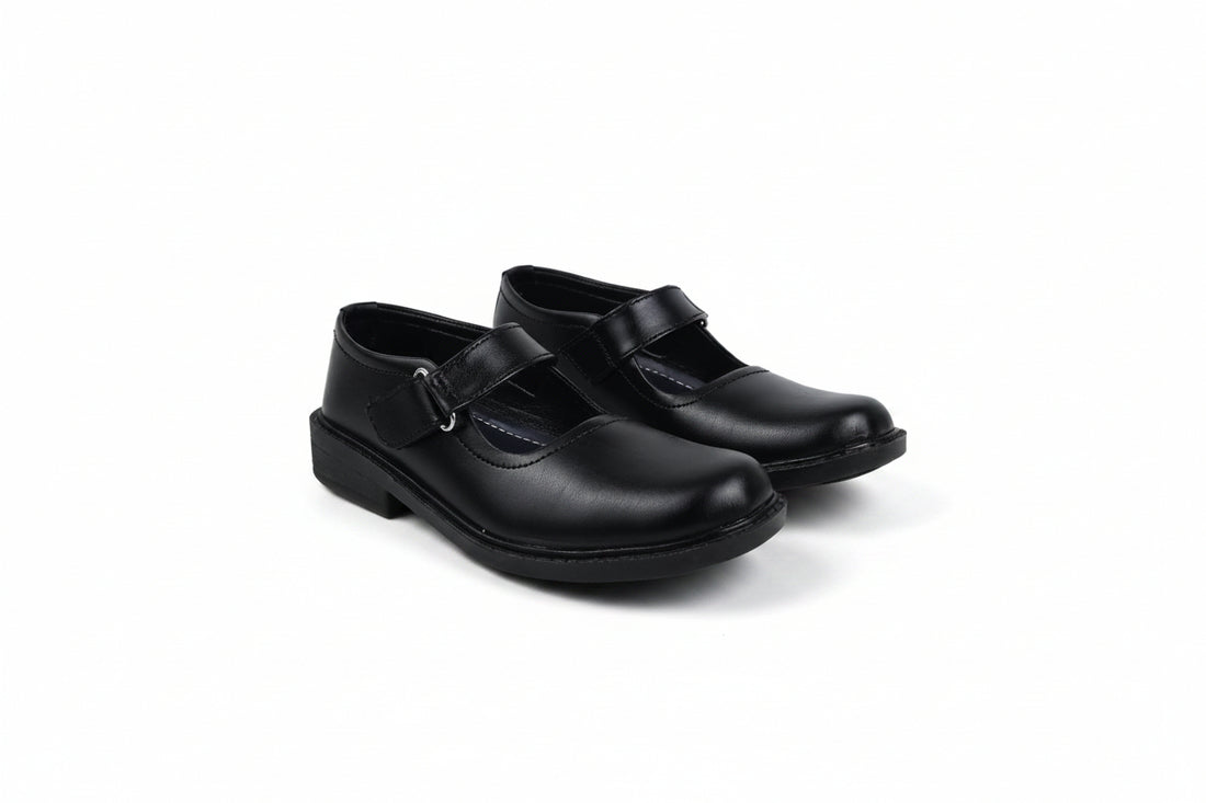 A pair of black patent leather Mary Jane school shoes with hook-and-loop straps, shown on a plain white background.