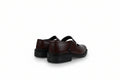 A pair of dark brown leather Mary Jane shoes with black soles, shown from a rear three-quarter angle against a white studio backdrop.