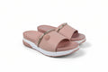 A pair of women's platform slide sandals in a dusty pink color, featuring a metallic gold chain detail across the strap and a thick white platform sole.