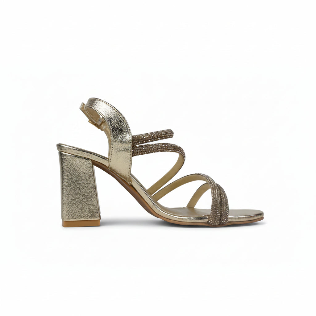 A metallic gold block-heel sandal with multiple thin straps, including two embellished with sparkling rhinestones, shown from a side profile on a white background.