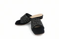 A pair of black suede mule sandals with wide straps heavily embellished with silver rhinestones, shown on a white studio background.