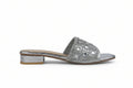 A single silver metallic slide sandal with a low block heel, featuring a wide strap embellished with square rhinestones, shown against a light gray background.