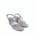 A pair of women's silver block-heel sandals with iridescent rhinestone-embellished straps, shown on a light gray fabric background.