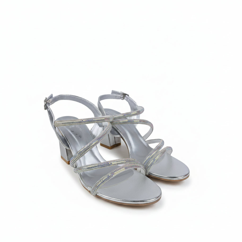 A pair of women's silver block-heel sandals with iridescent rhinestone-embellished straps, shown on a light gray fabric background.