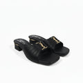 A pair of black leather slide sandals with a low block heel and a gold-tone metal YSL logo buckle, shown on a light gray background.