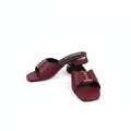 A pair of burgundy leather mule sandals with gold-tone hardware and a small YSL logo detail, displayed on a white studio background.