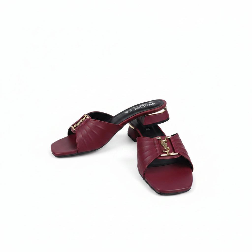 A pair of burgundy leather mule sandals with gold-tone hardware and a small YSL logo detail, displayed on a white studio background.