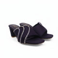 A pair of dark purple open-toe heeled sandals with glittery silver wrap-around straps, photographed on a white studio background.
