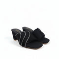 A pair of black heeled mule sandals with wide straps decorated with silver rhinestone-like trim, photographed on a plain light background.