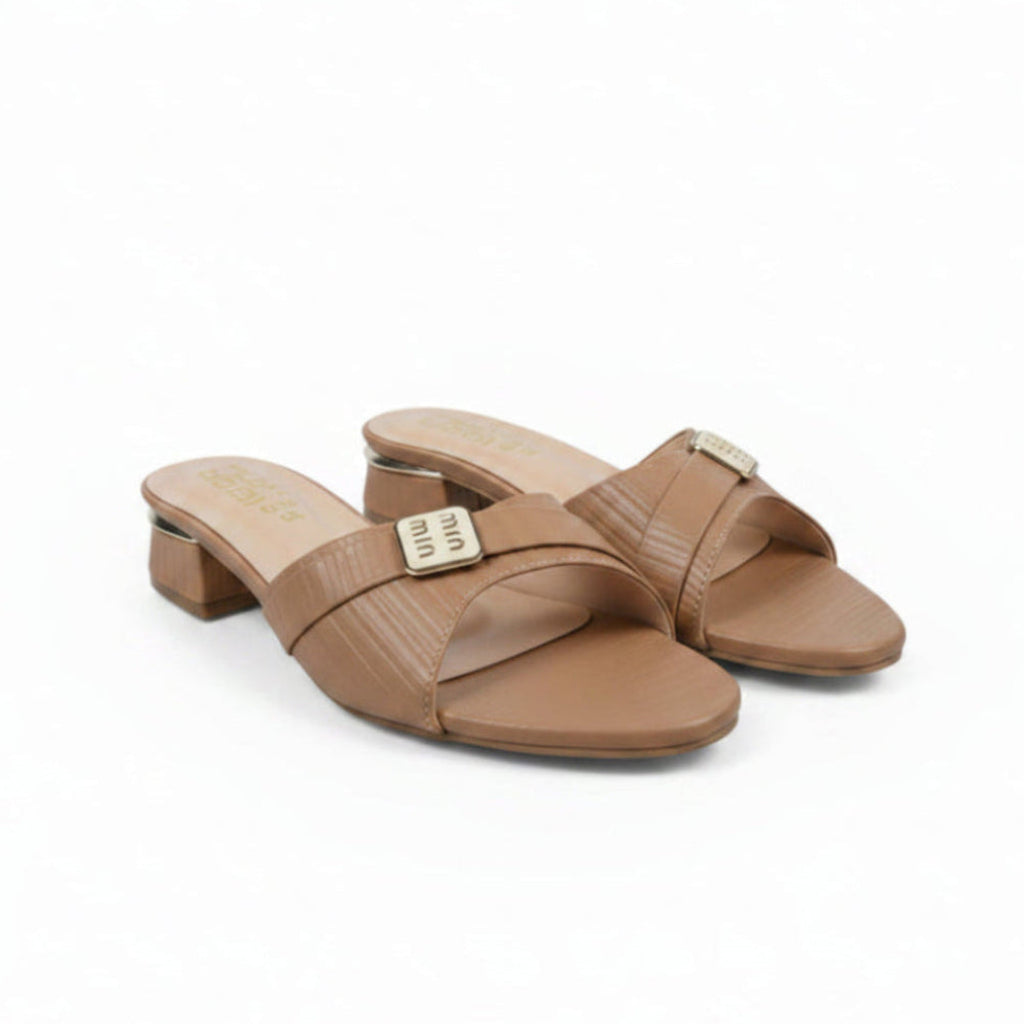 A pair of beige faux-croc leather slide sandals with low block heels and a gold-tone metal buckle on the strap, displayed on a white surface.