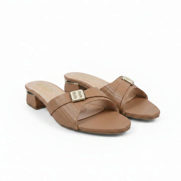 A pair of beige faux-croc leather slide sandals with low block heels and a gold-tone metal buckle on the strap, displayed on a white surface.