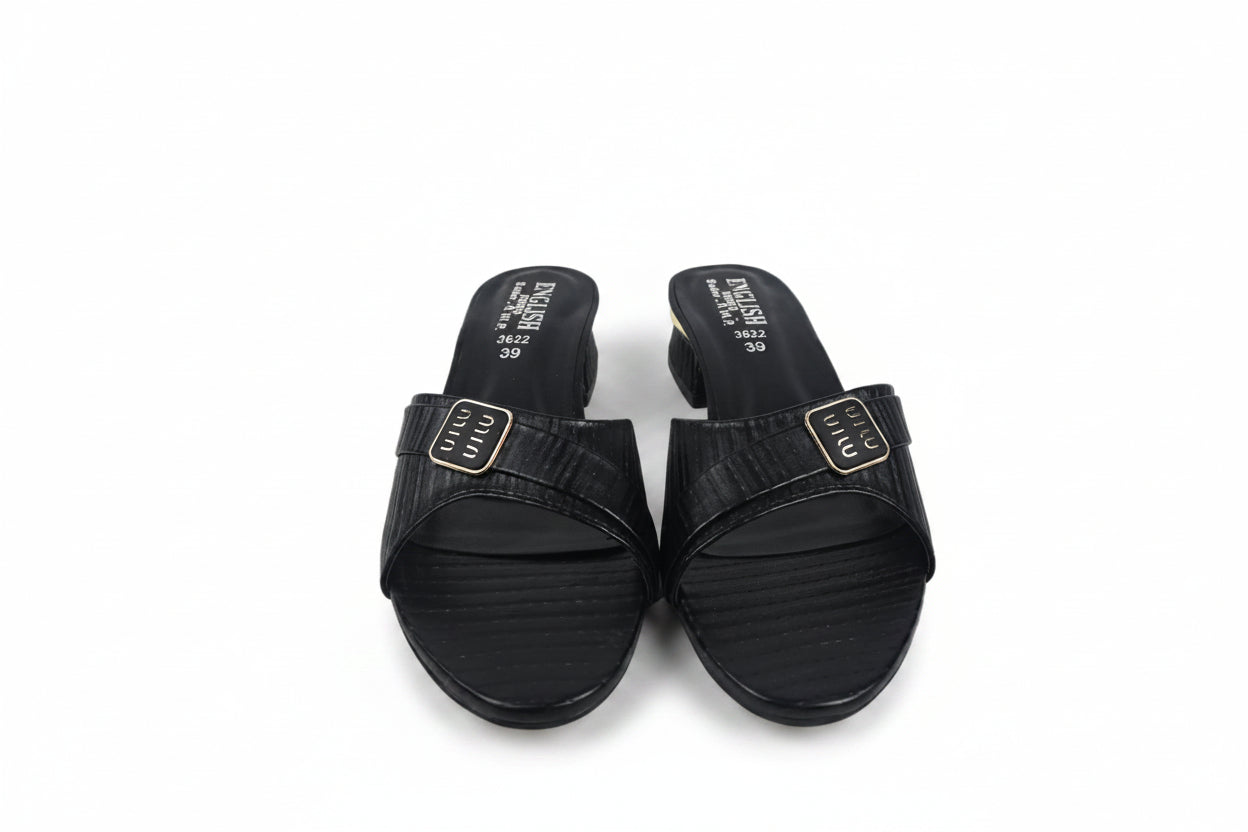 A pair of black slide sandals with textured straps and gold-tone square buckles, shown on a light gray background.