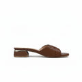 A single brown leather slide sandal with a textured, embossed pattern and a low block heel, shown from a side profile against a light gray background.