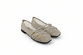 A pair of beige fishnet flat shoes with double gold buckle straps, photographed on a light gray studio background.