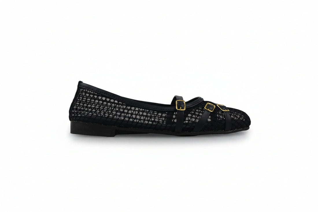 A pair of beige fishnet flat shoes with double gold buckle straps, photographed on a light gray studio background.