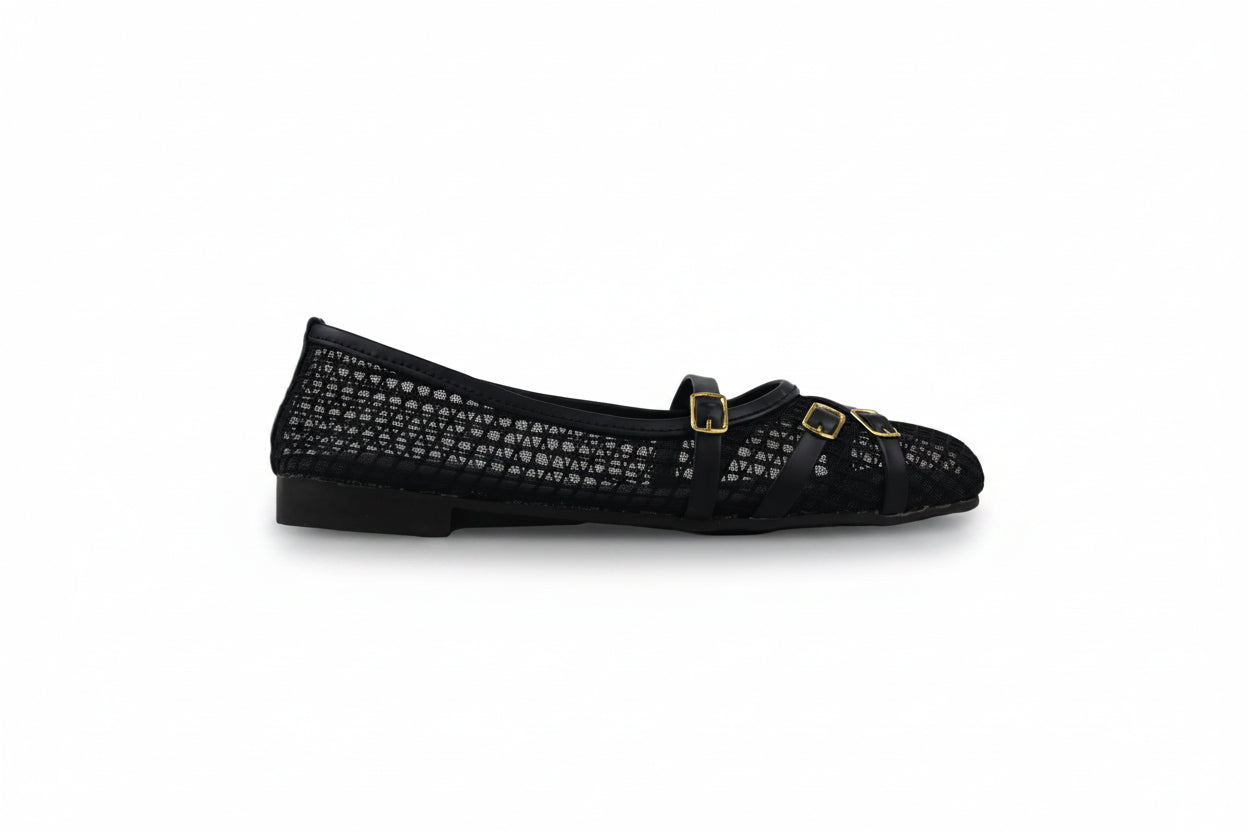 A single black flat shoe with a textured, perforated upper and two small gold buckle straps across the top, photographed against a light gray background.