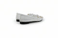A pair of white woven leather ballet flats with gold-tone hardware and white laces, shown from a side-rear angle on a light gray background.