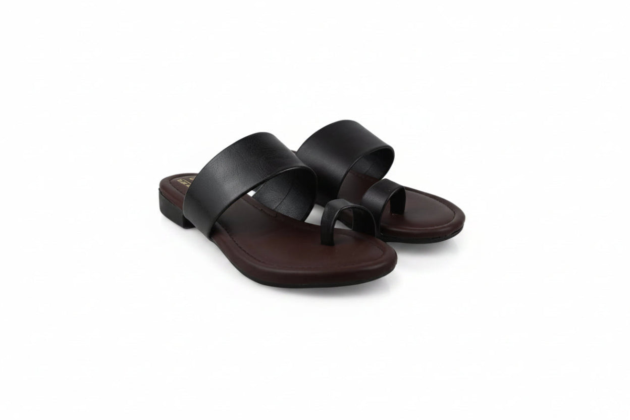 A pair of women's minimalist slide sandals in dark brown leather, featuring wide upper straps and a thong toe, displayed on a white studio background.
