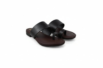 A pair of women's minimalist slide sandals in dark brown leather, featuring wide upper straps and a thong toe, displayed on a white studio background.