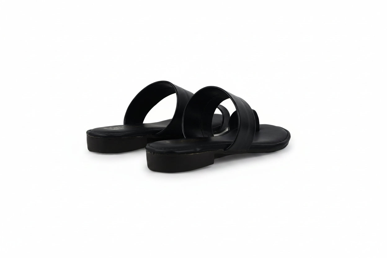 A pair of black leather slide sandals with wide double straps and low stacked platform soles, shown on a light gray background.