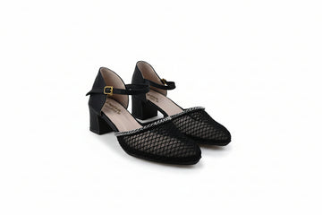 A pair of black fishnet Mary Jane heels with block toes, ankle straps, and gold buckle details, photographed on a light gray studio background.