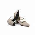 A pair of women's block-heel mule sandals in beige and gold, featuring a textured fishnet upper, pointed toe, and ankle strap, shown against a light gray background.
