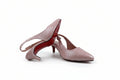 A pair of light pink leather slingback pumps with kitten heels and pointed toes, featuring the signature red sole of Christian Louboutin.