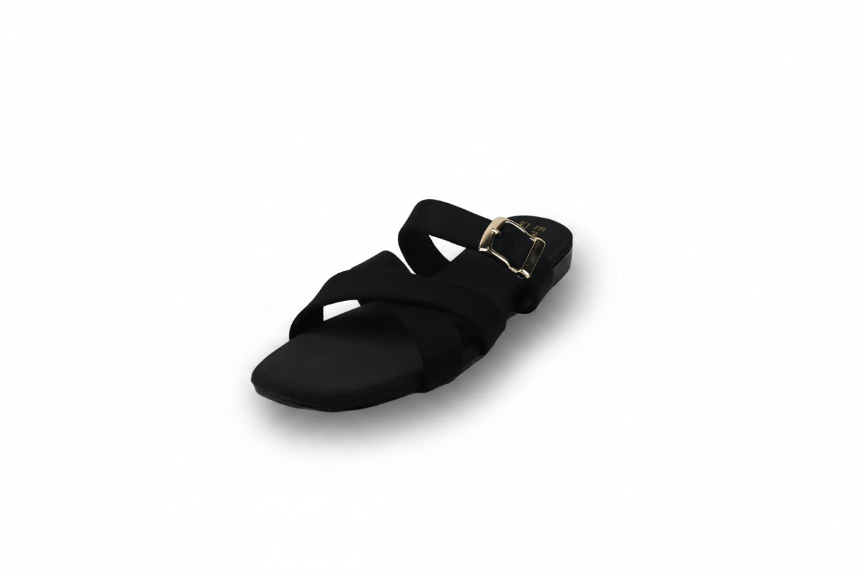 A single black flat sandal with crisscross straps and a gold-tone buckle, shown on a plain light gray background.
