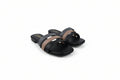 A pair of black slide sandals with two wide straps, one in black and one in taupe brown, featuring gold lettering on the insole.