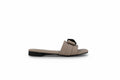 A single beige flat slide sandal with a wide padded strap and a black decorative accent on top, shown in profile against a light gray background.