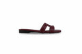 A single burgundy leather slide sandal with a cutout design on the toe strap, shown in profile against a light gray background.
