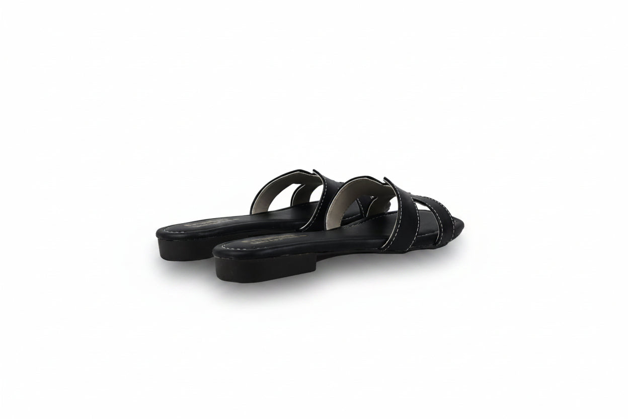 A pair of black leather slide sandals with double straps, shown from a side angle on a light gray studio background.