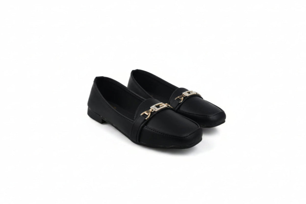 A pair of black leather loafers with a gold-tone metal chain detail across the vamp, displayed on a white studio background.
