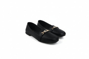 A pair of black leather loafers with a gold-tone metal chain detail across the vamp, displayed on a white studio background.
