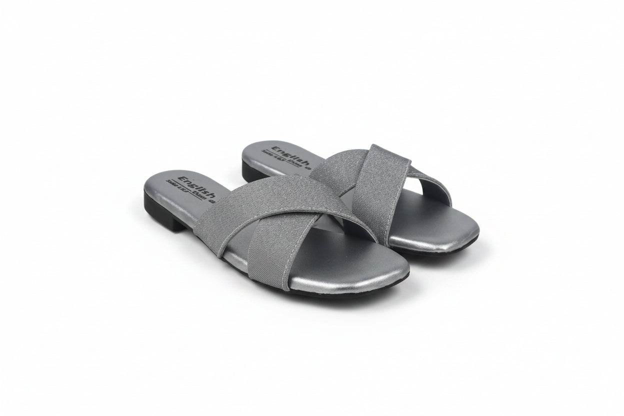 A pair of women's slide sandals in metallic silver with crisscrossing straps, shown on a light gray background.