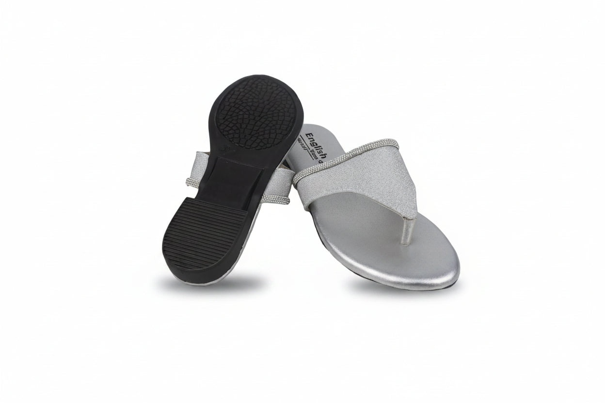A pair of women's thong sandals with metallic silver glitter straps and silver footbeds, with one sandal turned upside down to show the black textured outsole.