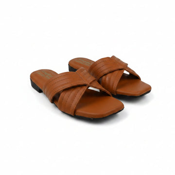 A pair of women's slide sandals in a warm cognac brown faux leather, featuring crisscrossing straps and low block heels, shown on a white studio background.