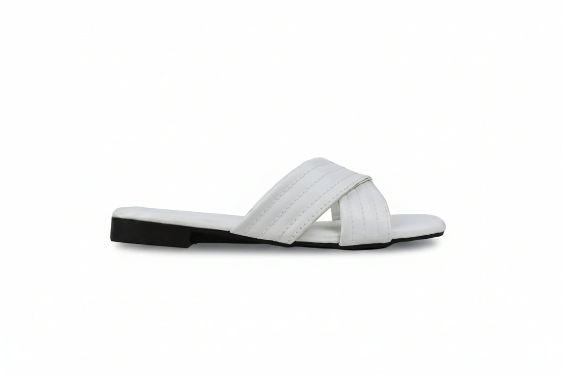 A pair of women's slide sandals in a warm cognac brown faux leather, featuring crisscrossing straps and low block heels, shown on a white studio background.