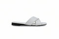 A single white leather slide sandal with a low black heel, shown in profile against a light gray background.