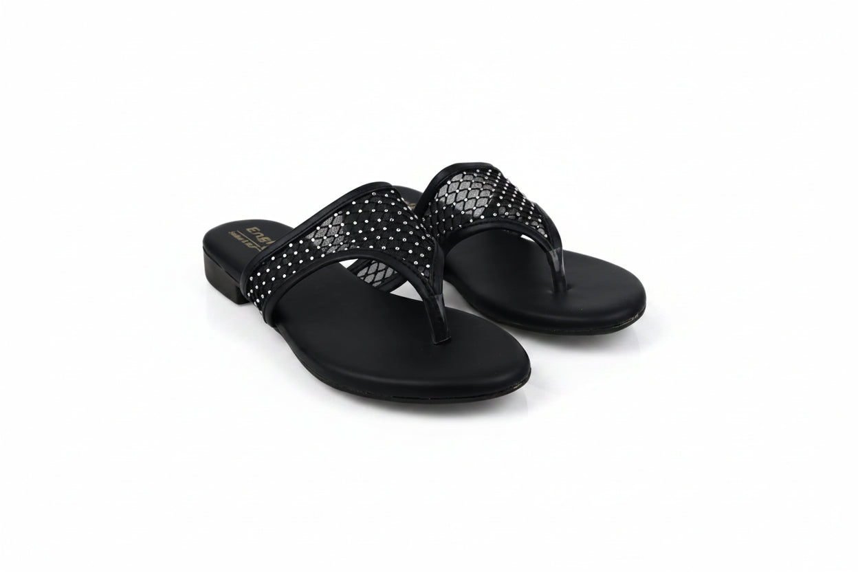 A pair of black slide sandals with rhinestone-embellished straps, photographed on a light gray studio background.