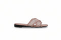 A single women's flat slide sandal in a dusty pink color, featuring a textured openwork woven pattern across the upper straps and a solid pink footbed, set against a light gray background.