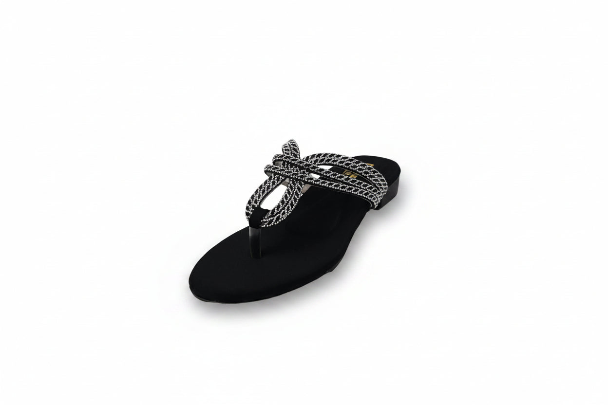 A single black thong sandal with a decorative woven strap featuring black and white stripes and a small gold logo, photographed on a white studio background.