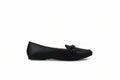A single black leather penny loafer flat shoe shown in profile against a light gray textured studio background.