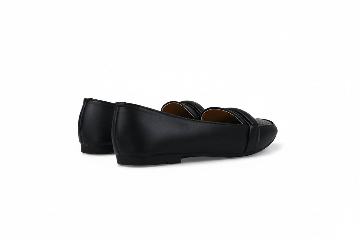 A pair of black leather penny loafers shown from the side against a plain white studio background.
