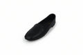 A single black leather loafer shoe photographed on a plain light gray studio background.