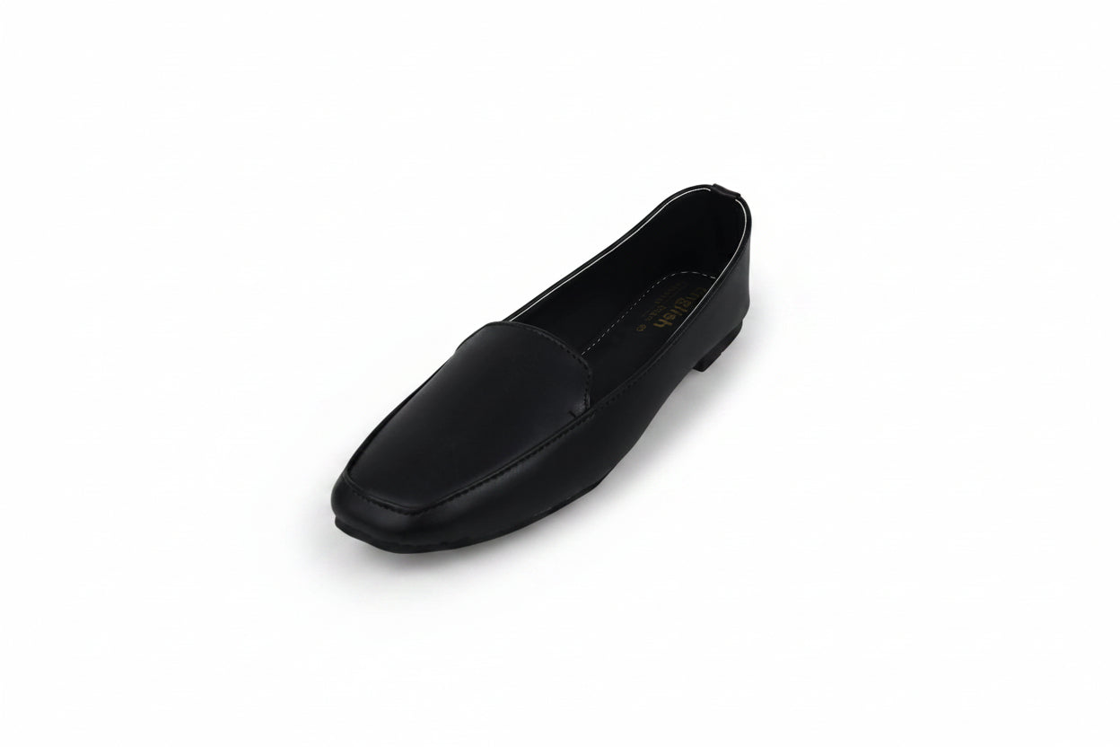 A single black leather loafer shoe photographed on a plain light gray studio background.