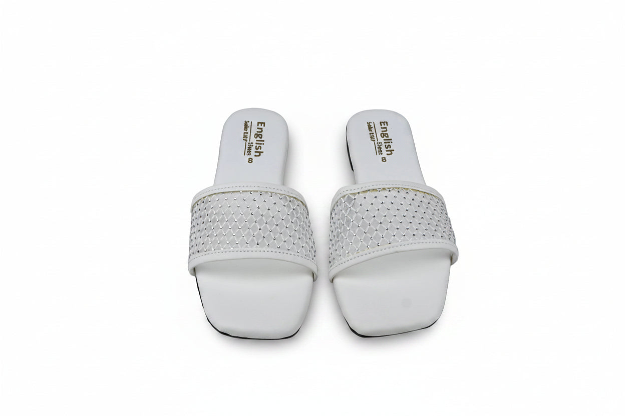 A pair of white slide sandals with rhinestone-embellished straps, shown from the top on a gray surface.