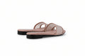 A pair of women's open-toe slide sandals with a light pink footbed and upper straps featuring a black-and-white woven geometric pattern, set against a plain light gray background.